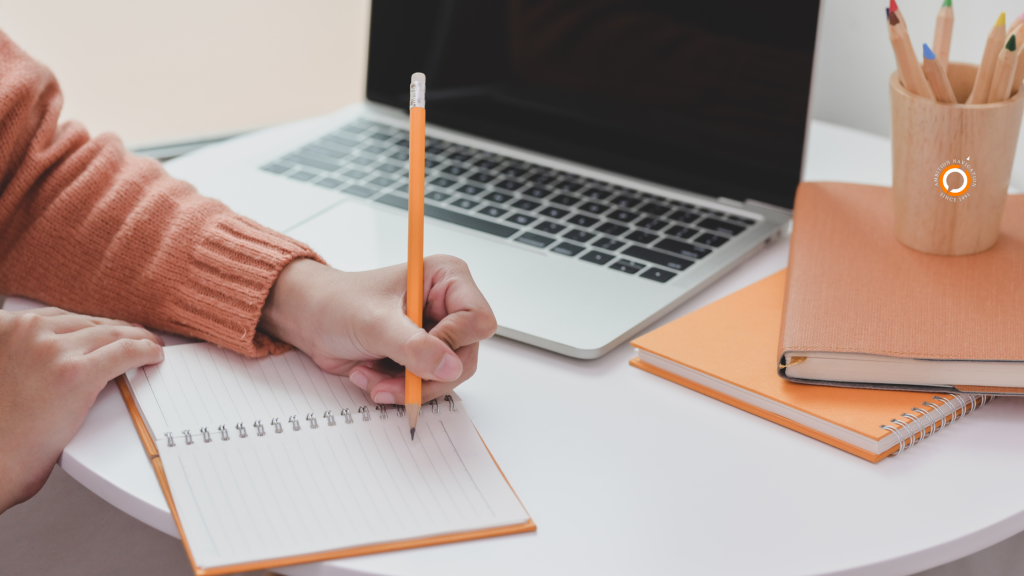 A person writing a career note during summer slump